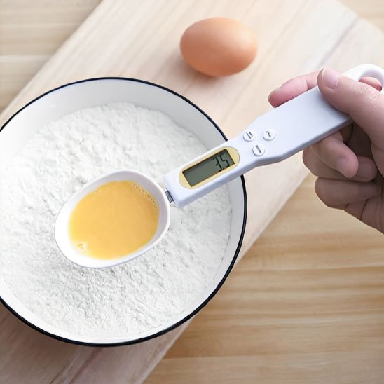 Cuillère doseuse électronique contenant de l'œuf fouetté pour faire du gâteau avec de la farine