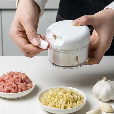 Mini hachoir manuel utilisé pour découper viande et légumes.