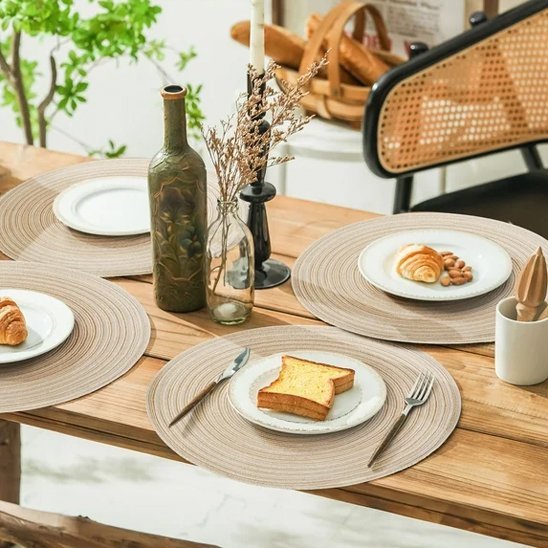 Set de table rond gris posé sur une table en bois pour le service.
