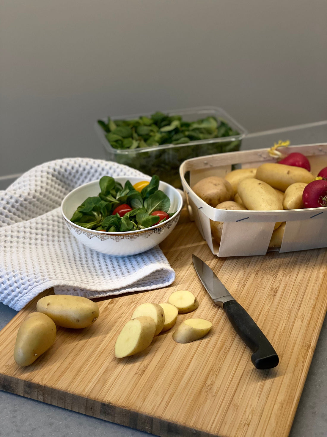 planche a decouper en bois avec des lamelles de pomme de terre dessus