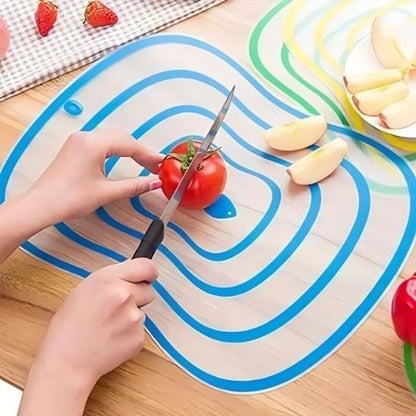 Surface de découpe utilisée pour trancher une tomate en cuisine