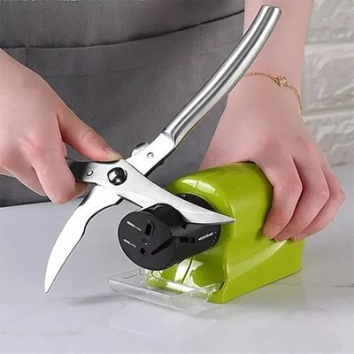 Affûtage d’un couteau de cuisine sur aiguiseur de couteau électrique vert.