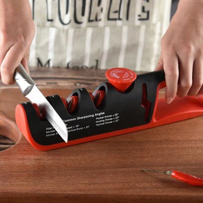 Aiguiseur de couteau avec double fente en pleine utilisation pour affûter une lame en acier.