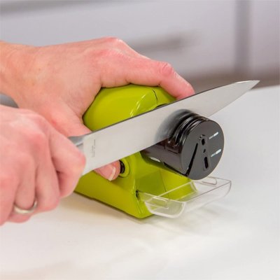 Aiguiseur de couteau électrique vert utilisé pour affûter une lame.