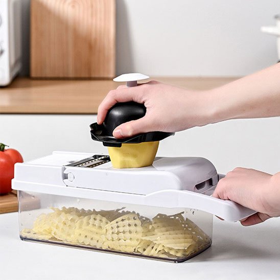Coupe‑légume mandoline utilisé pour découper une pomme de terre en gaufrettes.