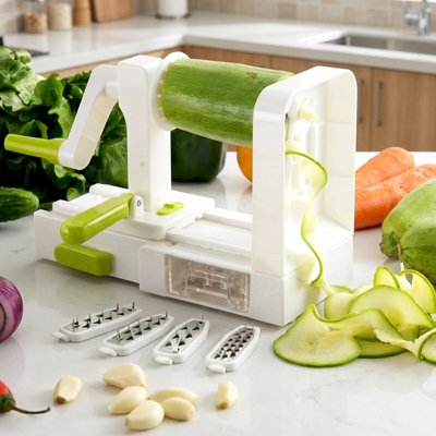 Coupe‑légume manuel transformant un concombre en longues spirales fines.