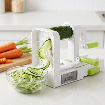 Coupe‑légume spiraliseur produisant des rubans de concombre dans un bol.