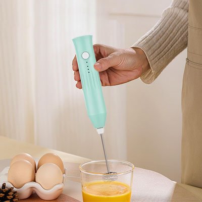 Création de mousse de lait avec mousseur électrique sur plan de cuisine.