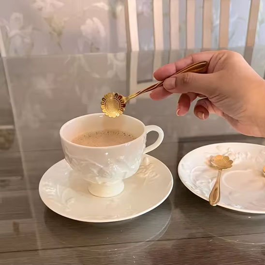 Cuillère à café dorée décorative, utilisée pour mélanger une boisson chaude.