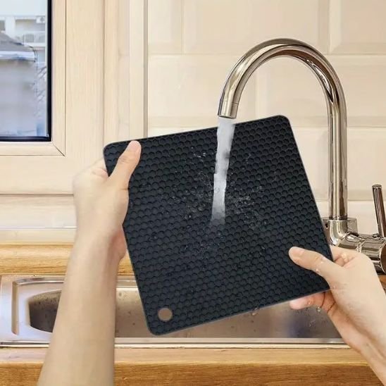 Dessous de plat moderne en silicone noir utilisé pour protéger la table.