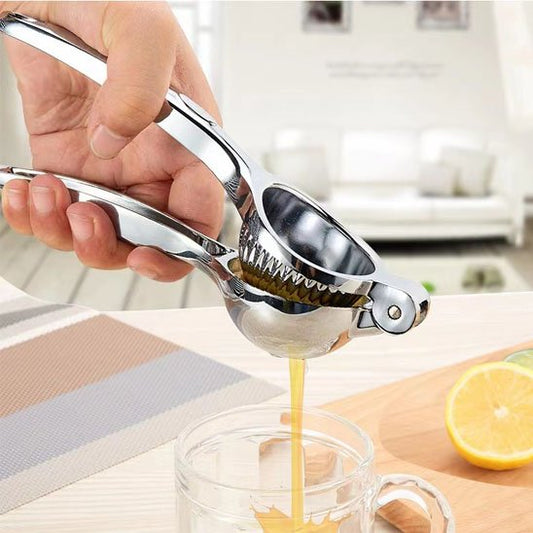 Extraction de jus de citron avec un presse agrume en inox sur plan de travail.