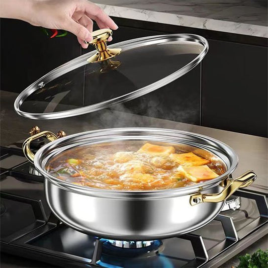 Faitout inox avec poignées dorées contenant une soupe chaude en cuisson.