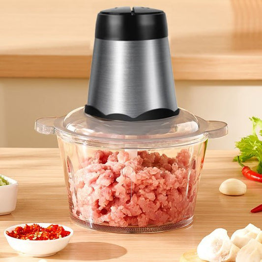 Hachoir electrique avec bol en verre rempli de viande hachée, idéal pour les préparations maison.