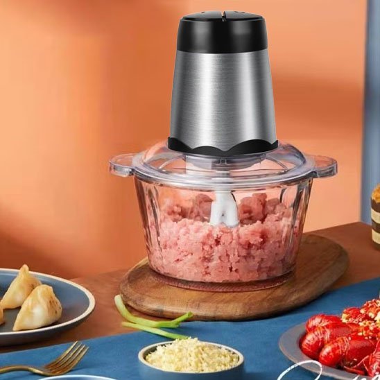 Hachoir electrique de cuisine utilisé pour mixer de la viande fraîche et des ingrédients.