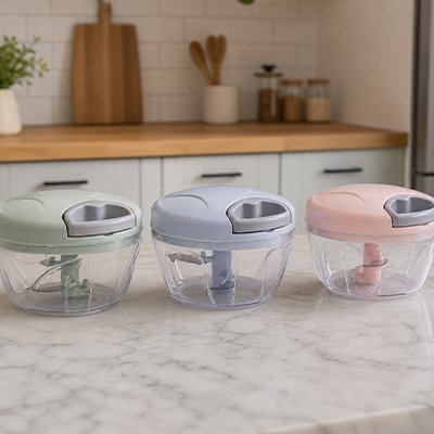 Hachoir manuel  de cuisine de couleurs différentes posés sur un comptoir de cuisine 
