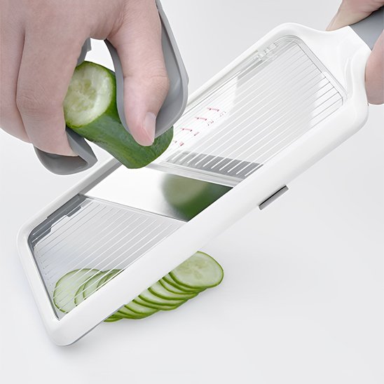 Mandoline manuelle utilisée pour couper un concombre en fines tranches