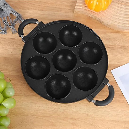 Moule à gâteau antiadhésif à sept empreintes rondes, idéal pour préparer des bouchées sucrées ou salées.