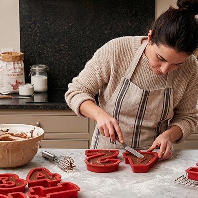 Moules en silicone rouges, alignés sur un comptoir de cuisine.