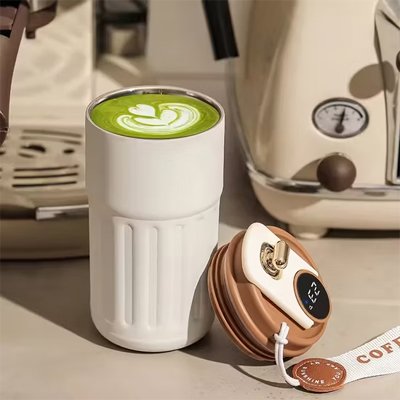 Mug isotherme blanc utilisé pour préparer une boisson chaude dans une cuisine cosy