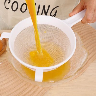 Passoire plastique résistante pour filtrer du jus d'orange au‑dessus d’un mélange l.