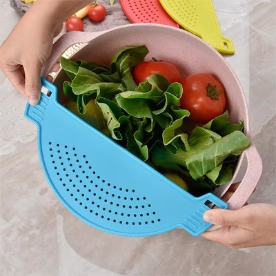 Passoire pratique en silicone posée sur une casserole pour retenir les aliments.