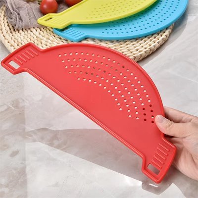 Passoire silicone résistante à la chaleur utilisée pour égoutter des pâtes au-dessus de l’évier.