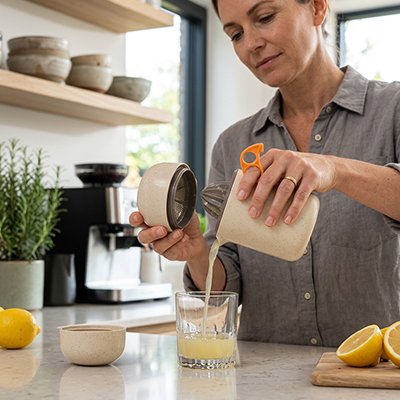 personne extrayant du jus d'orange frais d'un presse agrume dans une cuisine moderne