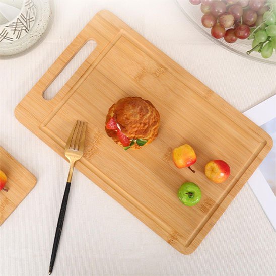 Planche à découper en bois avec tomates, ail et brocoli disposés pour la préparation culinaire.