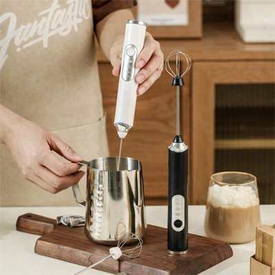 Préparation de lait mousseux avec un mousseur à lait électrique sur un comptoir de cuisine 