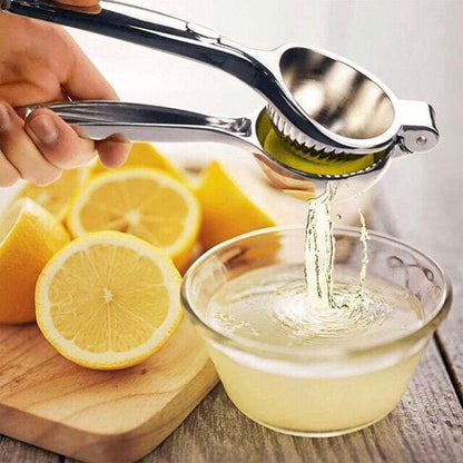 Presse agrume en acier inoxydable versant du jus dans une boisson glacée