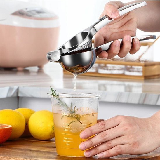 Presse agrume manuel utilisé pour extraire du jus de citron dans un verre.