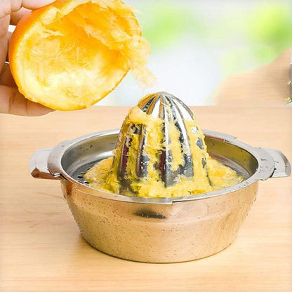 Presse agrumes en inox utilisé pour extraire du jus d’orange sur un plan clair.