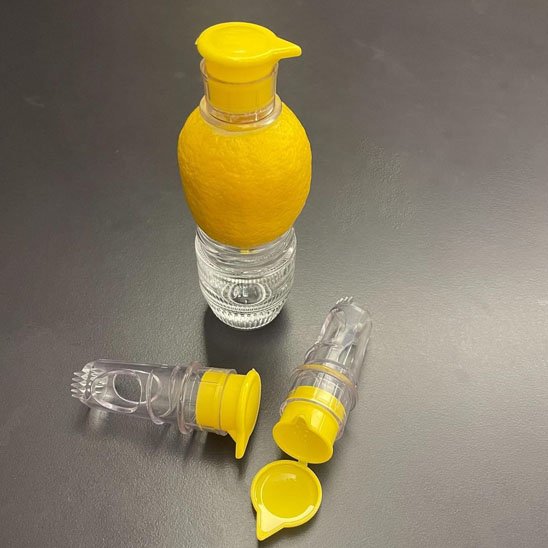 Presse‑agrume en action pour verser du jus dans un récipient.