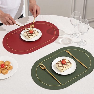 Set de table moderne rouge et vert mettant en valeur une assiette dessert et des couverts dorés sur une table blanche.