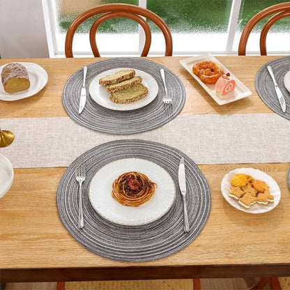 Set de table rond gris utilisé pour présenter une assiette de pâtes.