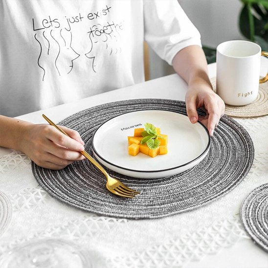 Set de table rond placé sous une assiette blanche lors du repas.