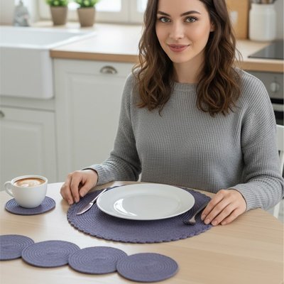 Set de table rond violet pour poser une assiette blanche sur une table de cuisine. 