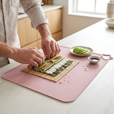 Set de table rose utilisé pour préparer un rouleau de sushi maison.