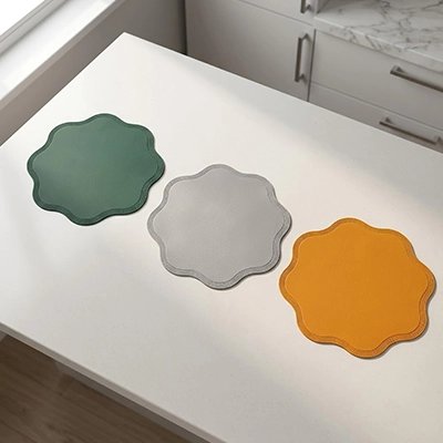 Set de table vert posé sur une table dressée pour un repas festif.