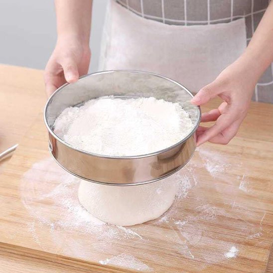 tamis_soupoudrant_la_farine_sur_une_pate